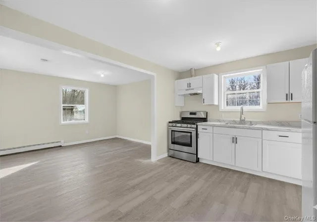 a kitchen with granite countertop a stove a sink and a refrigerator