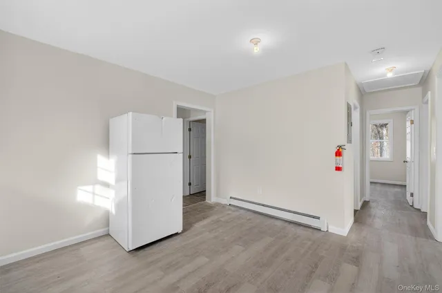 a view of a kitchen with a refrigerator and wooden floor