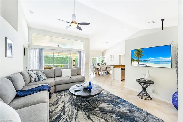 a living room with furniture a flat screen tv and a large window