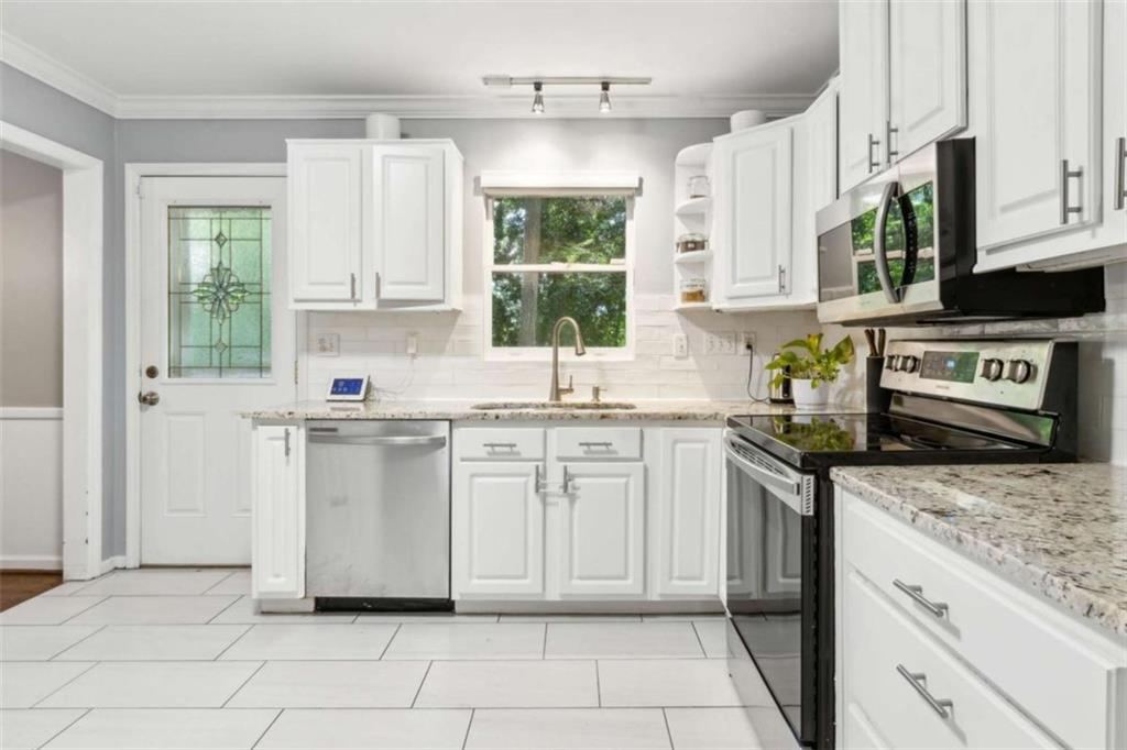 3362 Northbrook Drive Atlanta, GA 30340 - Photo 14 of 55 a kitchen with granite countertop white cabinets white appliances a sink and a window