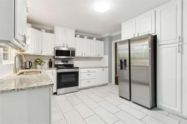 a kitchen with granite countertop a refrigerator stove and microwave