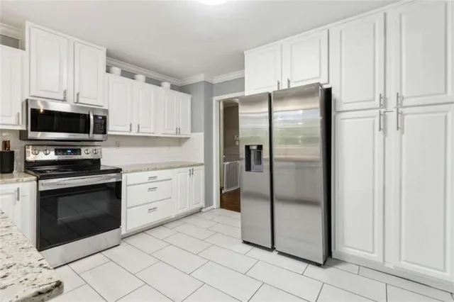 a kitchen with stainless steel appliances granite countertop a refrigerator and a stove top oven