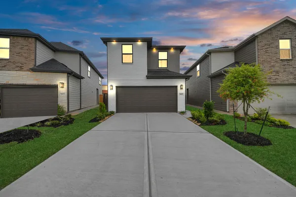 a front view of a house with a yard and a garage
