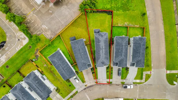 an aerial view of residential houses with outdoor space and street view