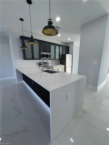 a kitchen with a sink a counter and chairs