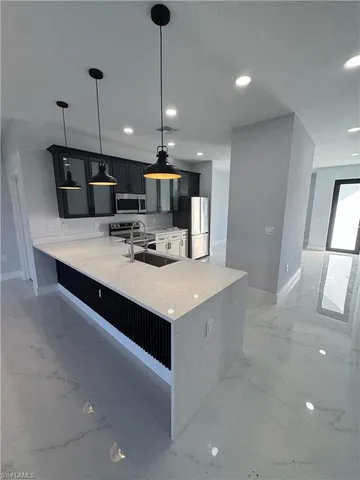 a large kitchen with stainless steel appliances a large counter top