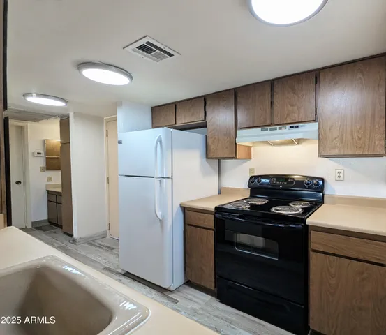 a kitchen with a refrigerator and a stove