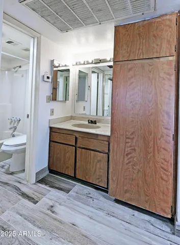 a bathroom with a granite countertop sink toilet and shower