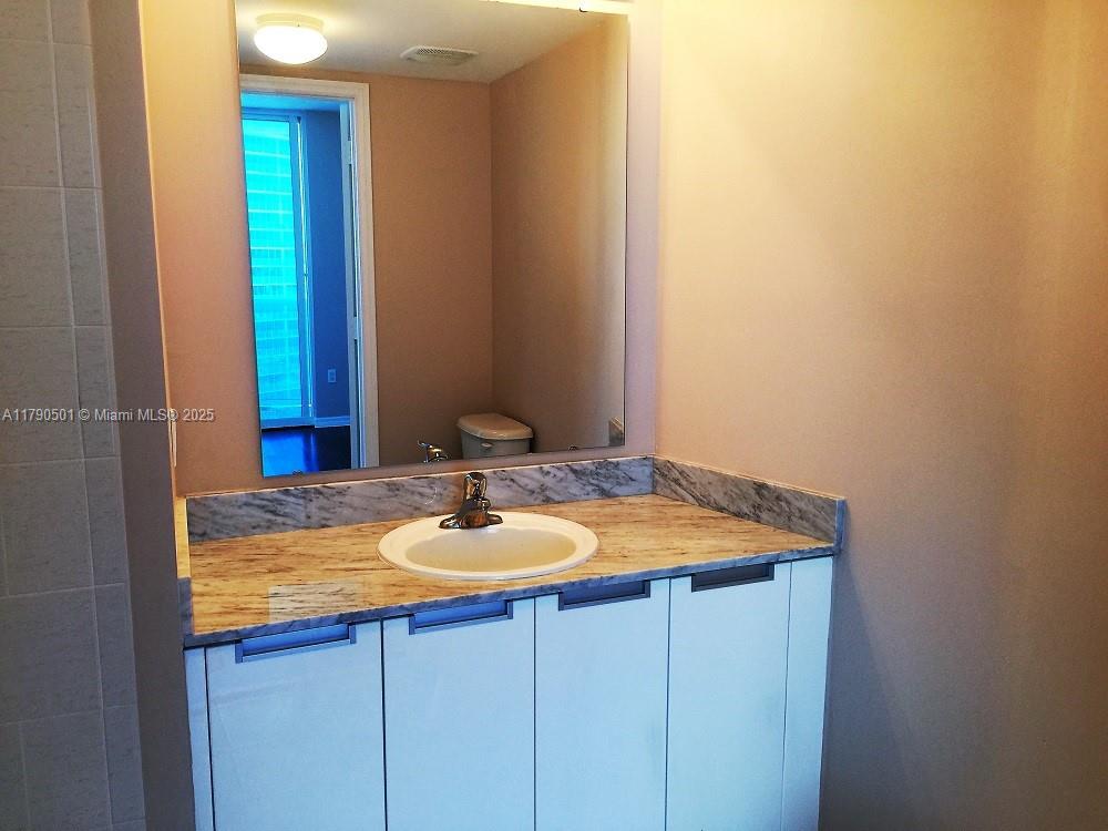 1881 79th Street Causeway, Unit 1106 North Bay Village, FL 33141 - Photo 13 of 20 a bathroom with a sink and a mirror