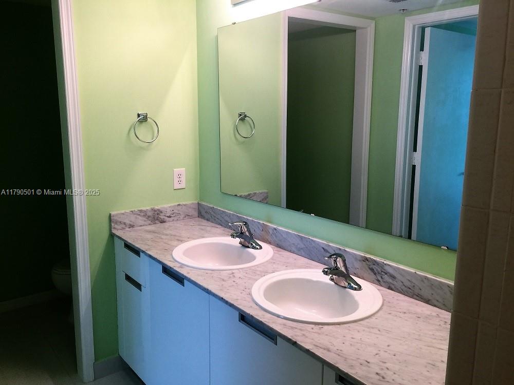 1881 79th Street Causeway, Unit 1106 North Bay Village, FL 33141 - Photo 10 of 20 a bathroom with a granite countertop sink and a mirror