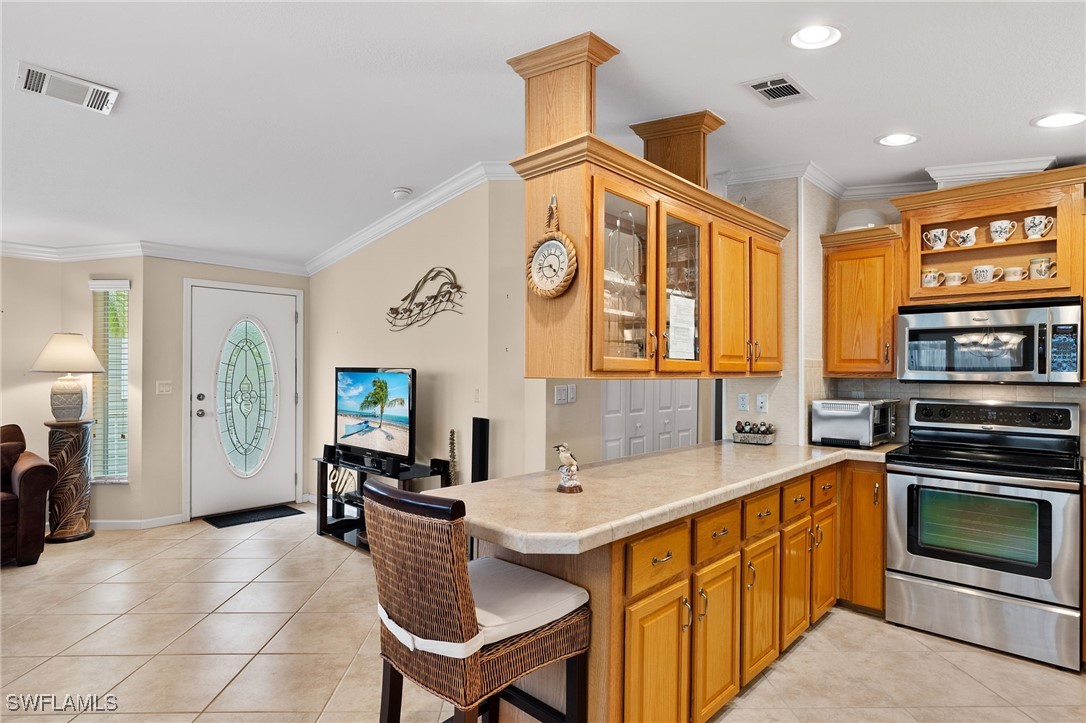 3057 Waterview Point Naples, FL 34120 - Photo 12 of 31 a kitchen with stainless steel appliances a stove a sink and a refrigerator