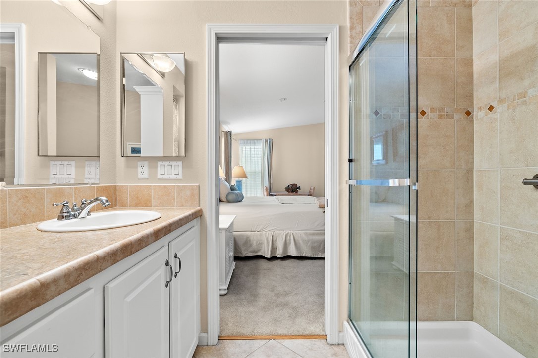 3057 Waterview Point Naples, FL 34120 - Photo 18 of 31 a en suite bathroom with a shower sink and mirror