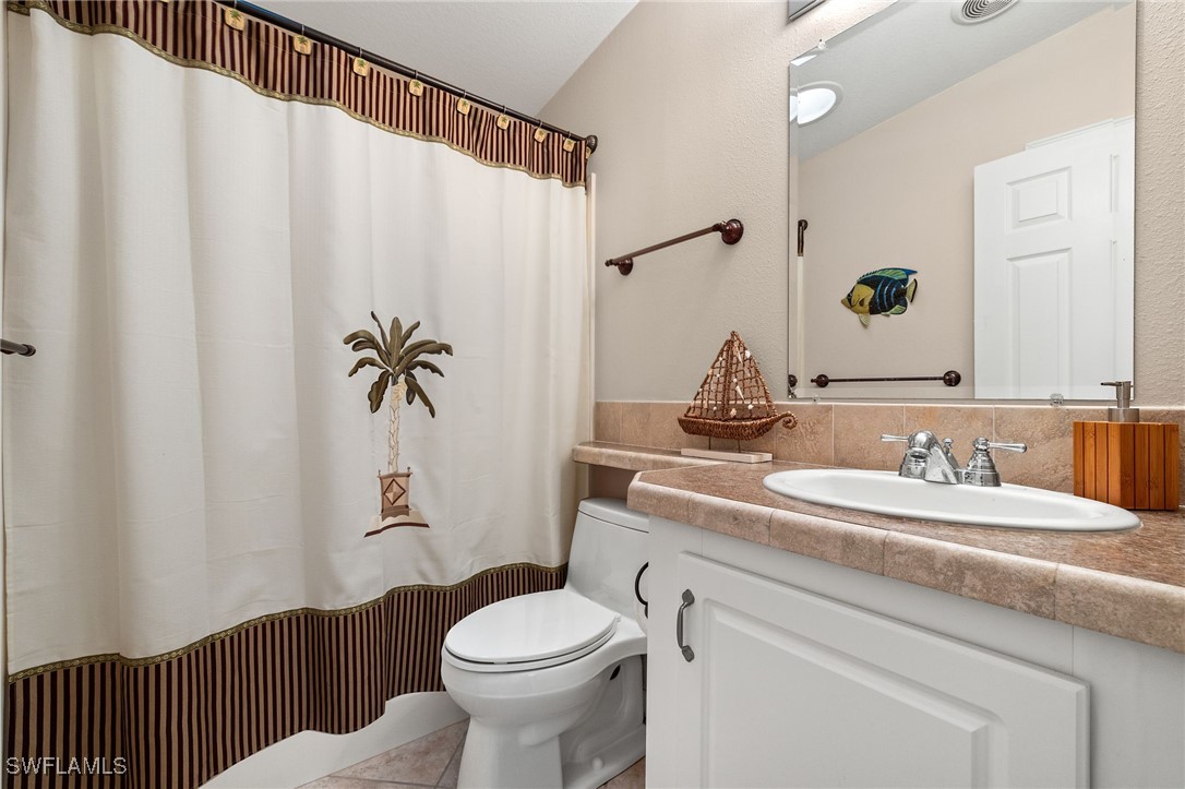 3057 Waterview Point Naples, FL 34120 - Photo 20 of 31 a bathroom with a sink a toilet and a mirror
