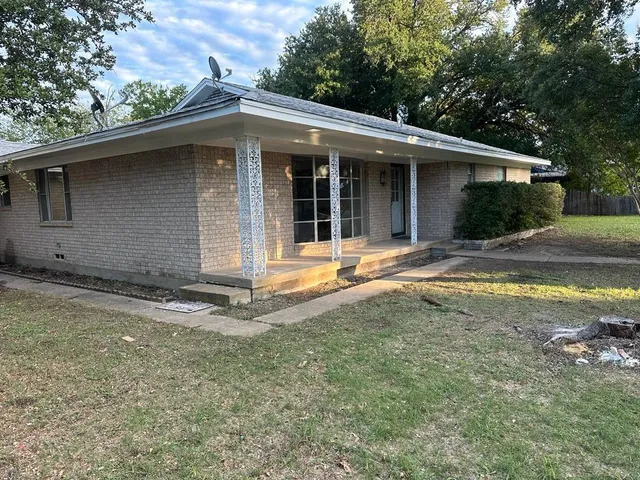 a view of a house with backyard and trees