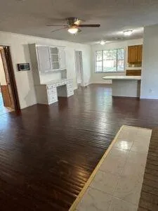 a view of empty room with wooden floor and window