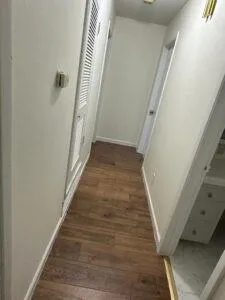 a view of a hallway with wooden floor and staircase