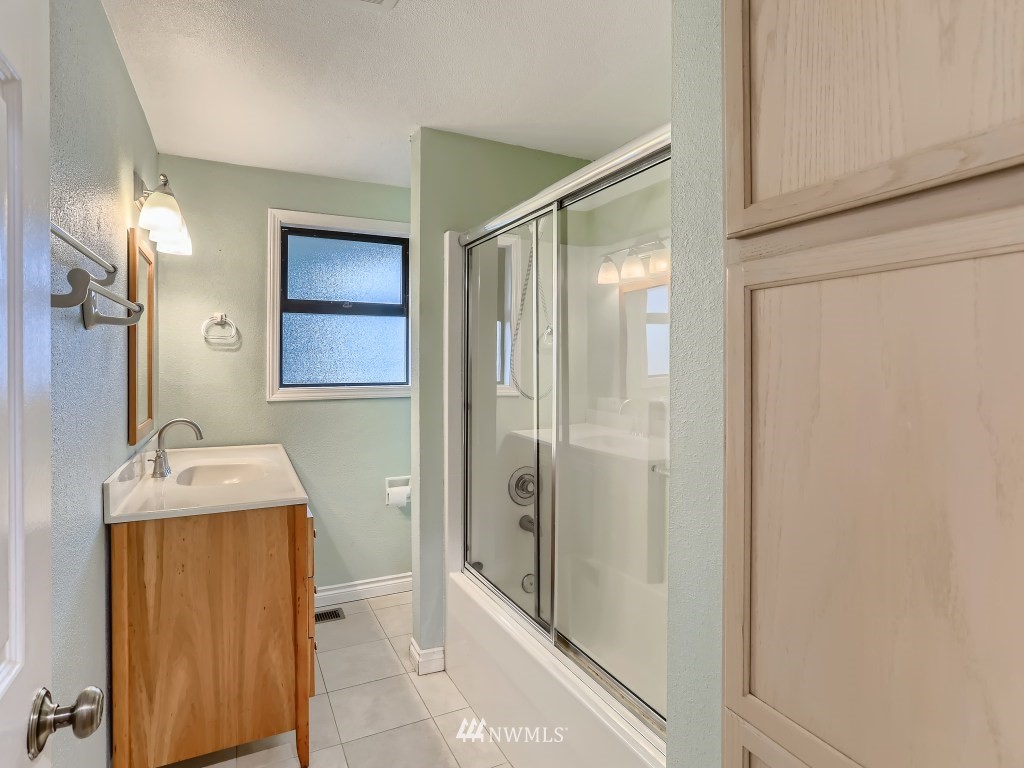 102 233rd Place Southwest Bothell, WA 98021 - Photo 17 of 26 a bathroom with a granite countertop sink a mirror and shower