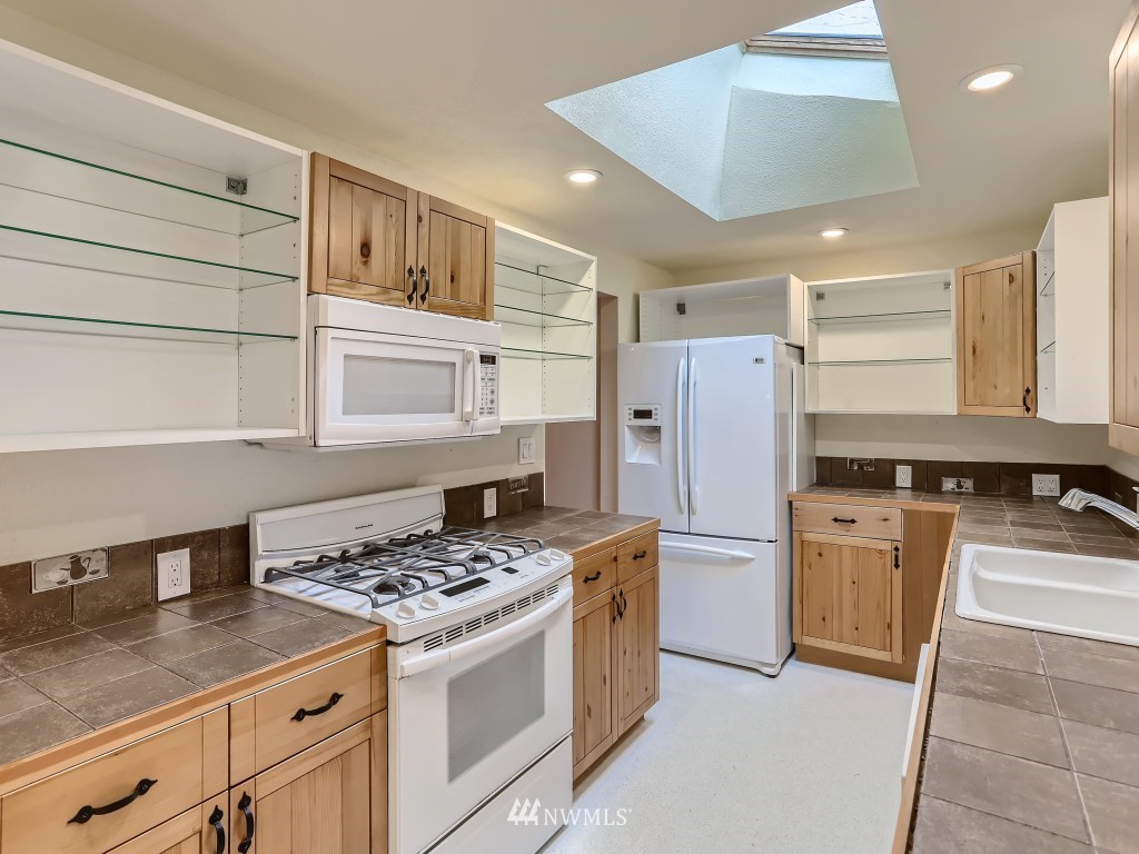 102 233rd Place Southwest Bothell, WA 98021 - Photo 9 of 26 a kitchen with a stove a refrigerator and a sink