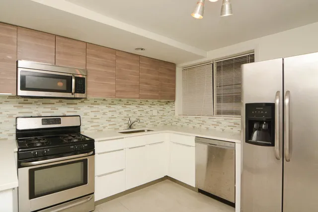 a kitchen with cabinets stainless steel appliances and a counter space