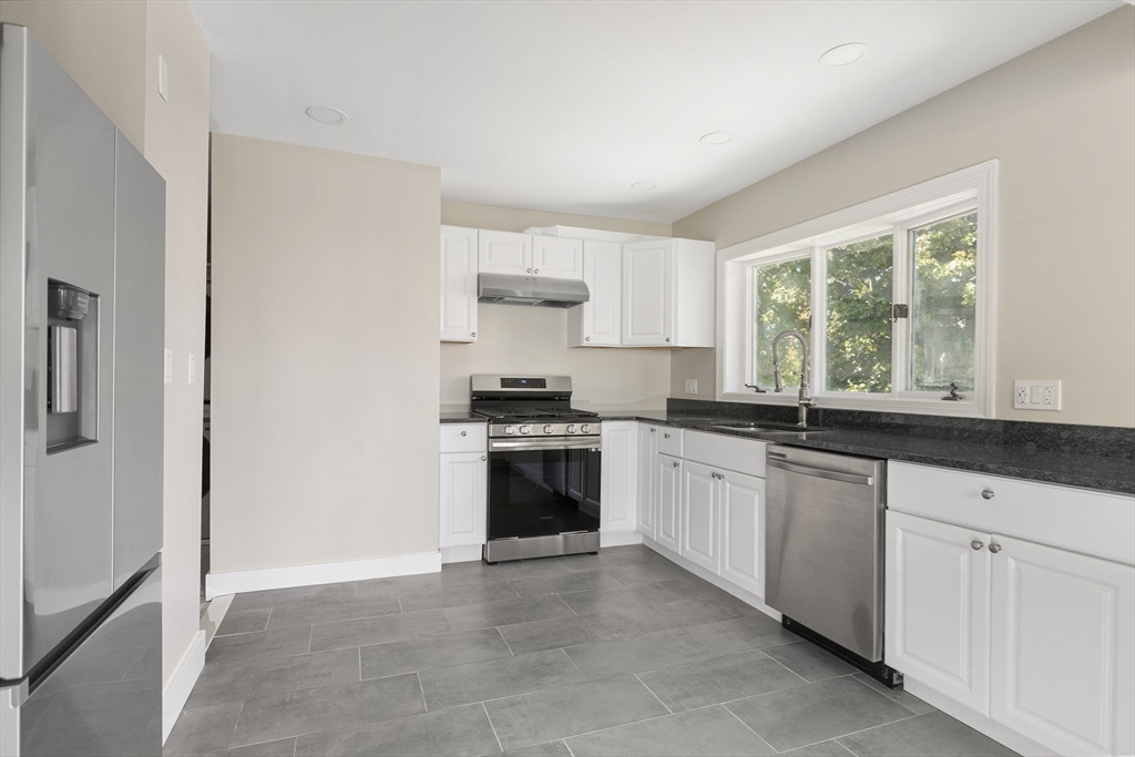 15 South Fairview Street, Unit 3 Boston, MA 02131 - Photo 6 of 29 a kitchen with granite countertop white cabinets and white appliances