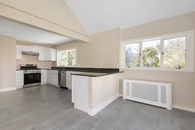 a kitchen with stainless steel appliances granite countertop a stove a sink and a microwave