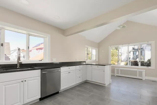a large white kitchen with a sink and cabinets