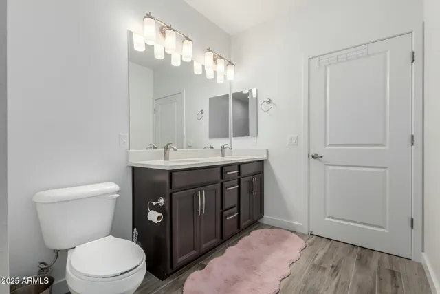 a bathroom with a sink vanity mirror and toilet