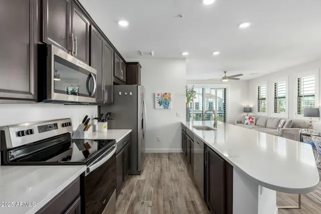 a large kitchen with stainless steel appliances granite countertop a lot of counter space and wooden floor