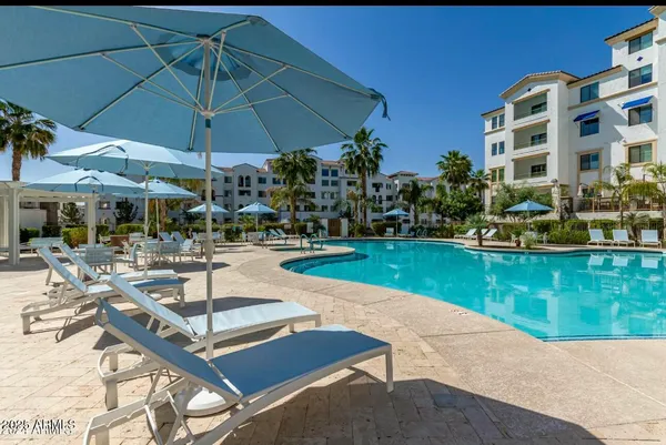 a patio with a table and chairs under an umbrella