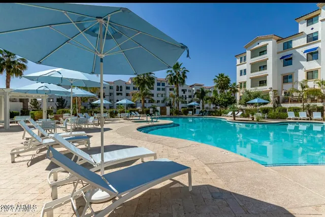 a patio with a table and chairs under an umbrella