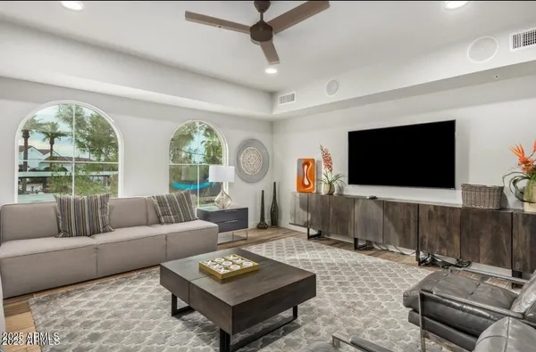 a living room with furniture a flat screen tv and a large window