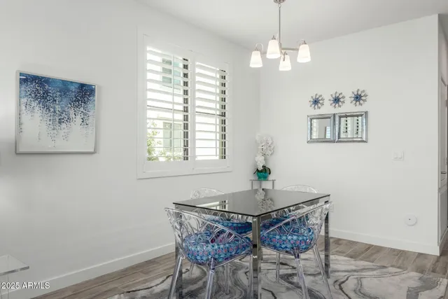 a dining room with wooden floor and a chandelier