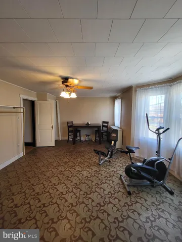 a living room with furniture a rug and gym equipment