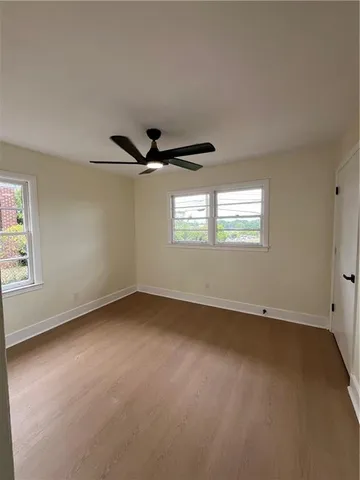 en empty room with windows and ceiling fan