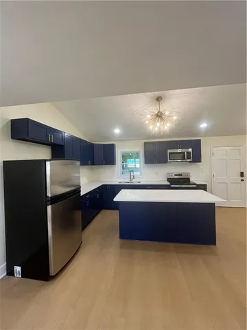 a large kitchen with stainless steel appliances a large counter top