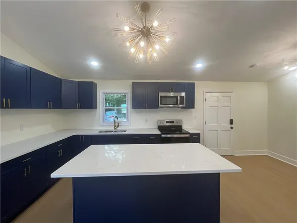 a kitchen with a sink a microwave and cabinets