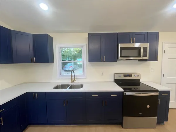 a kitchen with a sink a microwave and cabinets