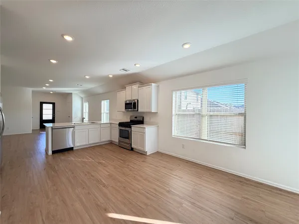 a view of a kitchen with furniture and wooden floor