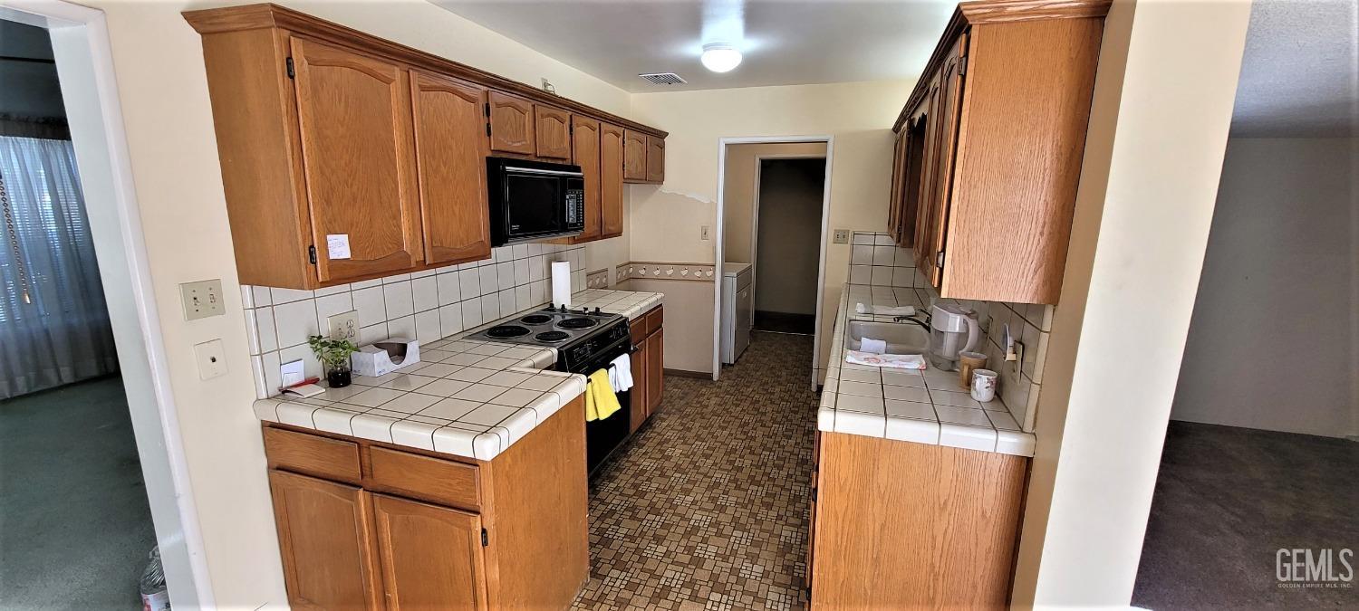Undisclosed Address Delano, CA 93215 - Photo 5 of 23 a living room with stainless steel appliances furniture a fireplace and a flat screen tv