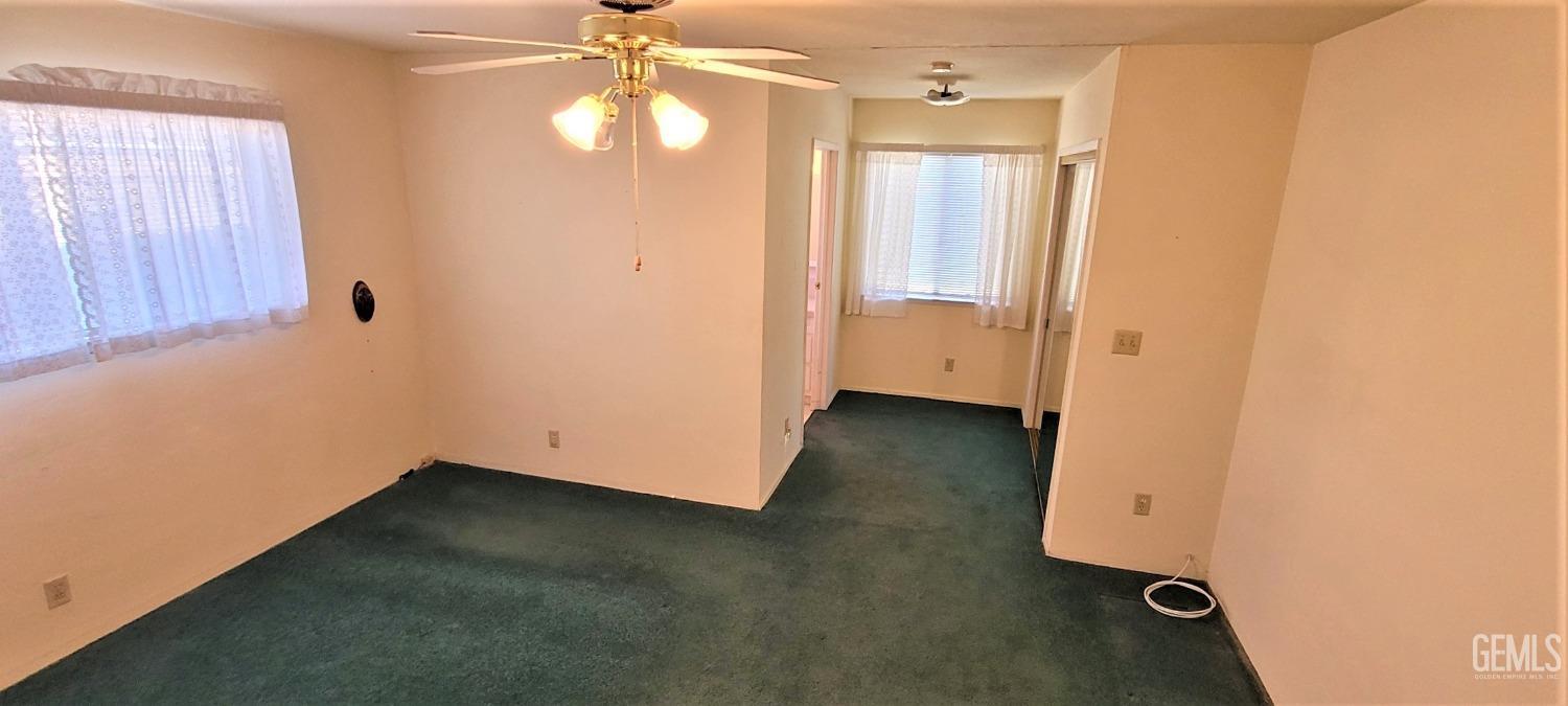 Undisclosed Address Delano, CA 93215 - Photo 9 of 23 an empty room with wooden floor and windows