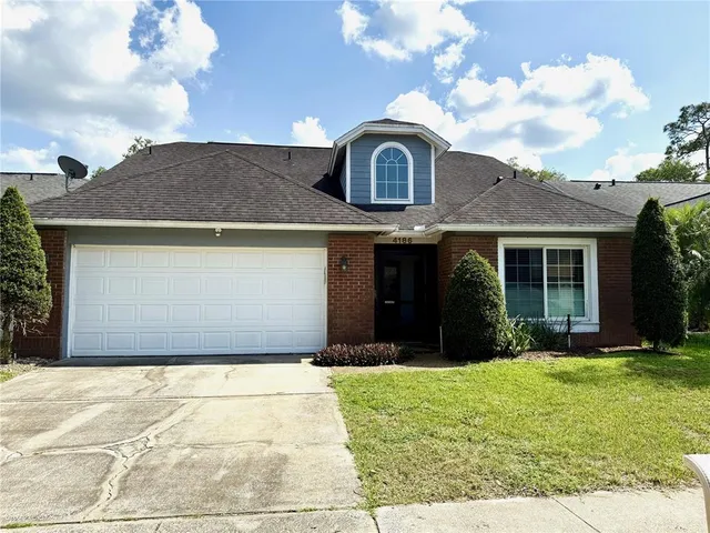 a front view of a house with a yard and potted plants
