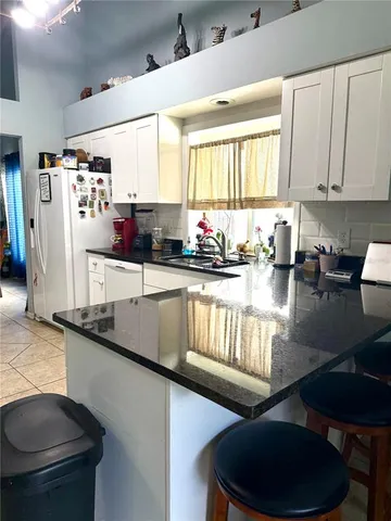 a kitchen with stainless steel appliances granite countertop a sink a stove and refrigerator