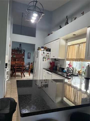 a kitchen with sink refrigerator and window