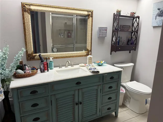 a bathroom with a sink vanity mirror and toilet