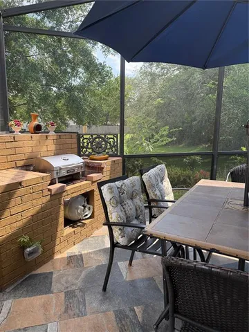 a view of a patio with table and chairs under an umbrella
