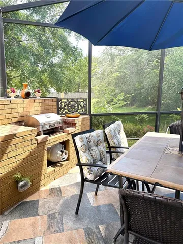 a view of a patio with table and chairs under an umbrella