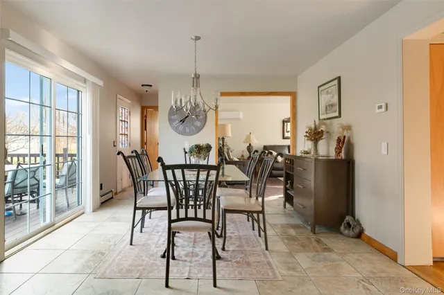 a view of a dining room and livingroom with furniture wooden floor a chandelier