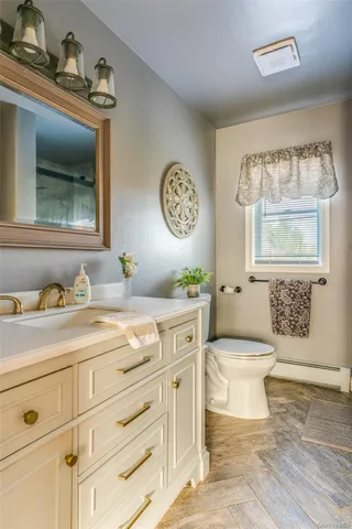 a spacious bathroom with a toilet sink and mirror