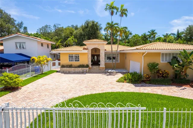 a front view of a house with a garden and yard
