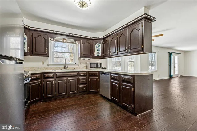 a kitchen with stainless steel appliances granite countertop a stove a sink and a microwave